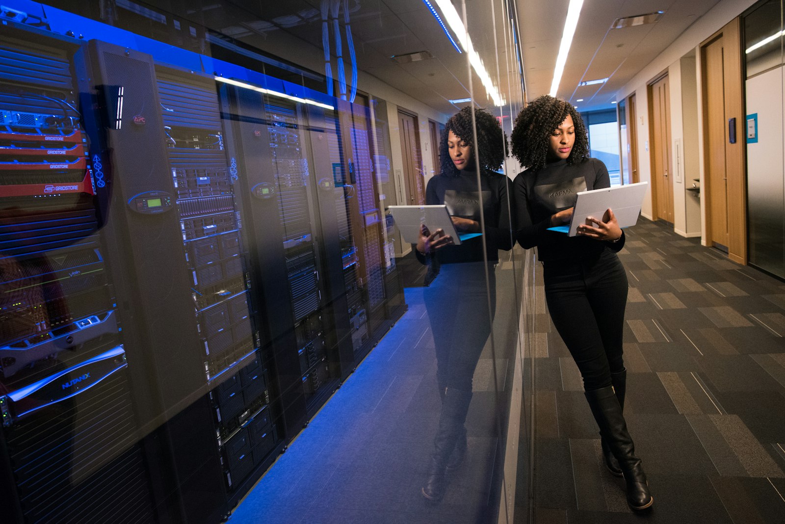 Engineer reviewing systems in a modern data center corridor