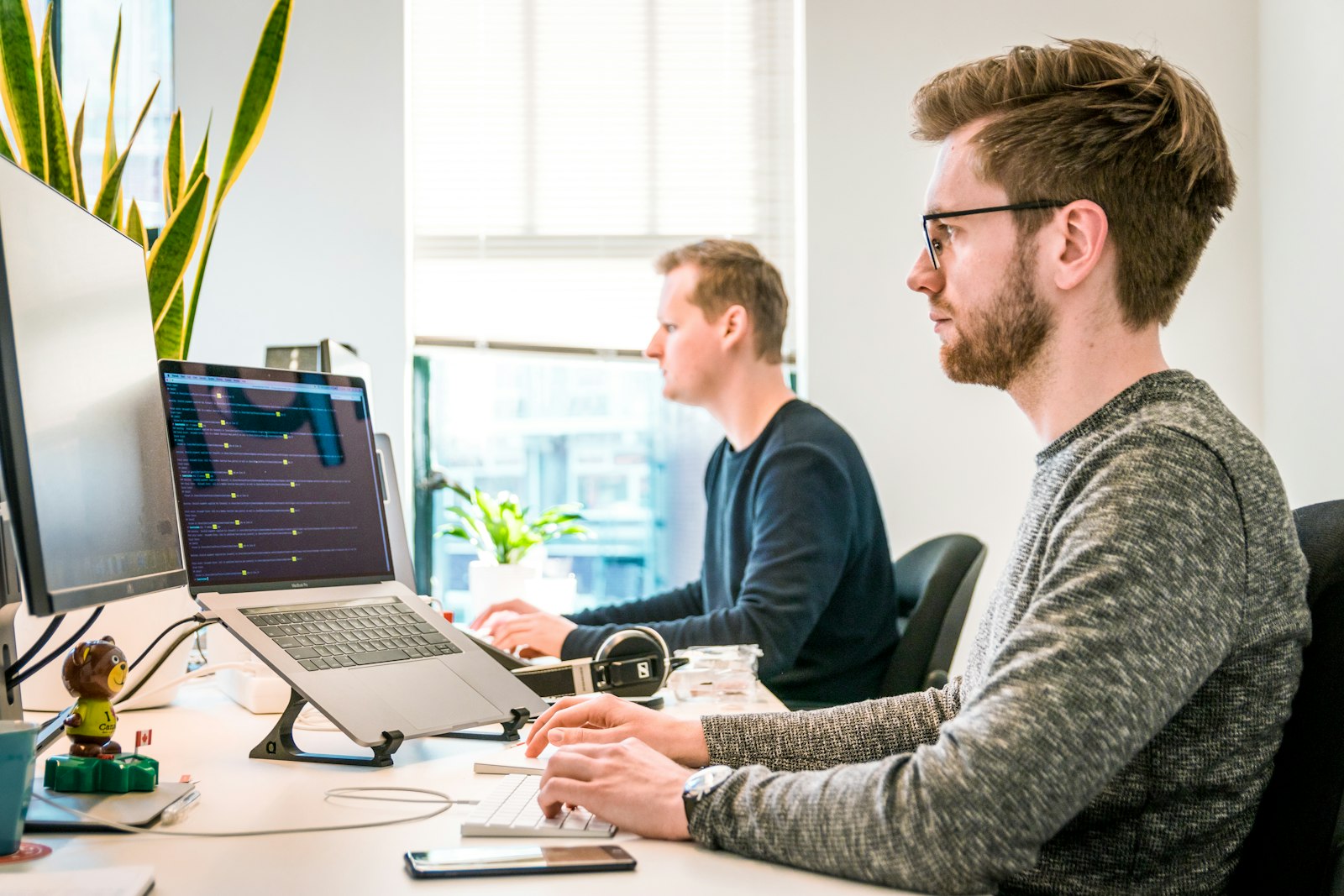 Software engineers working at side-by-side workstations