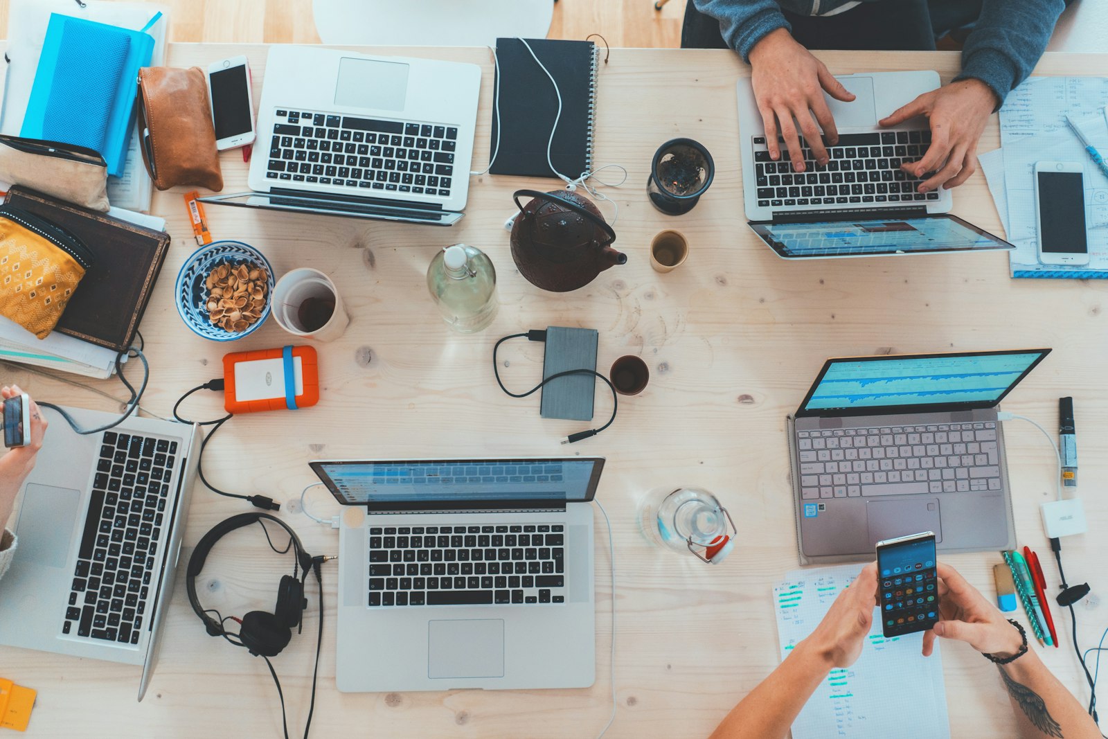 Overhead view of a team working together on laptops at a shared desk